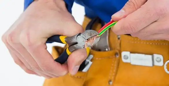 licensed electrician securing electrical wiring with professional tools during service work in Lakeland, FL