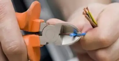 licensed electrician performing precise wire cutting and preparation during electrical service in Lakeland, FL