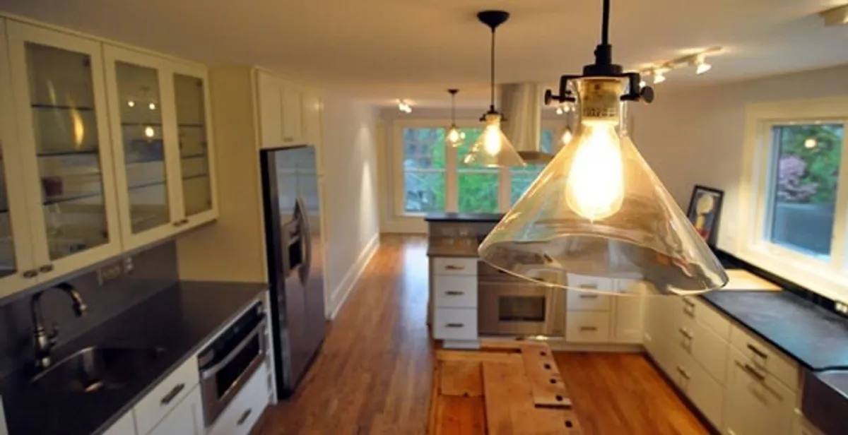 Residential electrician installing modern indoor light fixture in a home in Lakeland, FL