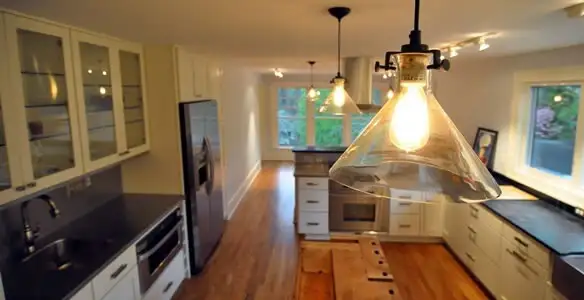 Residential electrician installing modern indoor light fixture in a home in Lakeland, FL