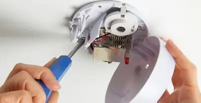 Certified technician wiring smoke detector during installation in Lakeland, FL